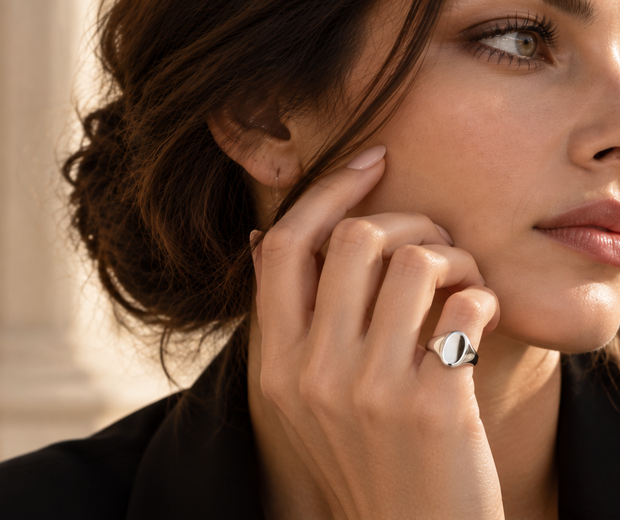 Woman wearing a polished silver pinky ring in a modern 2026 jewelry editorial